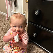 Blakelynn is registered to the contest to win money with this photo: baby, child, pajamas, carpet, brush, hair_bows, dresser, furniture, indoor, cute, sitting, playing, infant, floor, person, carpeted_floor, toy, knobs, room, colorful_clothing