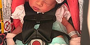 Irelynn is registered to the contest to win money with this photo: baby, newborn, car_seat, bow, mittens, sleeping, child, infant, clothing, seatbelt, colorful, patterned, cute, soft, pink, blue, white, cozy, resting, portrait