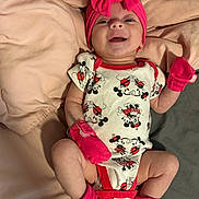Irelynn joined the competition — help win amazing prizes! adorable, baby, blanket, child, clothing, cute, happy, indoor, infant, lying_down, mickey_mouse, newborn, onesie, person, pink_headband, pink_mittens, pink_socks, portrait, smile, soft_texture