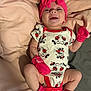 adorable, baby, blanket, child, clothing, cute, happy, indoor, infant, lying_down, mickey_mouse, newborn, onesie, person, pink_headband, pink_mittens, pink_socks, portrait, smile, soft_texture