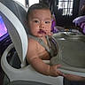 Armando is registered to the contest to win money with this photo: baby, high_chair, messy_face, purple_food, indoor, child, curious, looking_at_camera, furniture, window, door, tray, seatbelt, sitting, expression, young_child, face, arm, floor, room