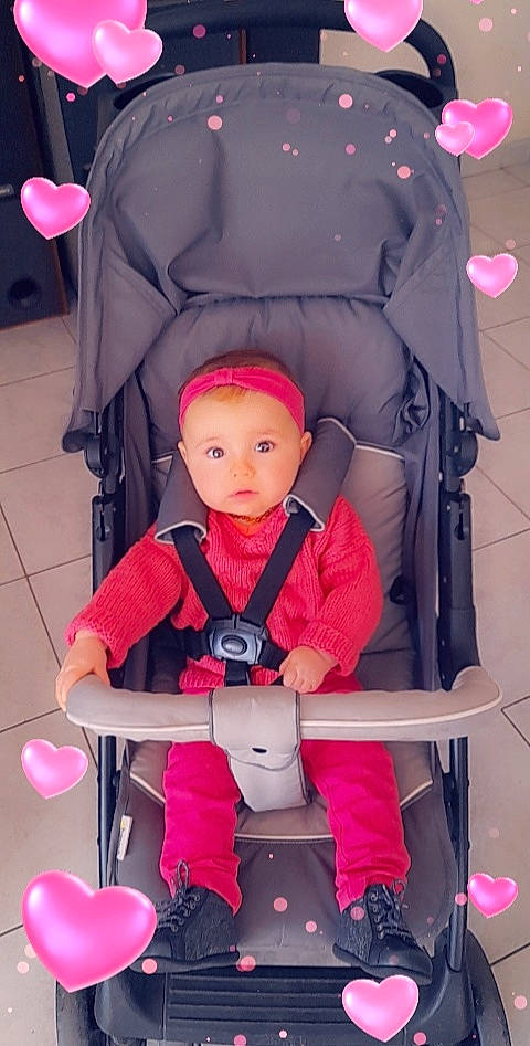 Mila a rejoint le concours — aidez-le/la à gagner de superbes lots ! baby, baby_carriage, baby_toddler_clothing, balloon, chair, child, comfort, face, fun, lap, magenta, people, person, pink, product, purple, red, toddler, wheel, white