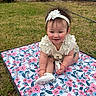 Kamila is registered to the contest to win money with this photo: baby, child, smiling, outdoor, grass, flower_mat, headband, white_clothing, cute, happy, sitting, person, young_child, lawn, garden, shoes, flower_pattern, playtime, nature, portrait