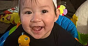 Kamila is registered to the contest to win money with this photo: baby, headband, smile, toy, activity_center, indoor, furniture, living_room, child, colorful, happy, person, playtime, infant, cute, clothing, face, hand, hair, earring
