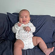 Edwin joined the competition — help win amazing prizes! baby, child, infant, smiling, happy, portrait, sitting, couch, sofa, cushions, indoors, living_room, white_onesie, clothing, barefoot, hands, legs, face, photography, home