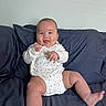 baby, child, infant, smiling, happy, portrait, sitting, couch, sofa, cushions, indoors, living_room, white_onesie, clothing, barefoot, hands, legs, face, photography, home