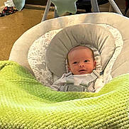 Madelyn joined the competition — help win amazing prizes! baby, blanket, infant, baby_seat, green, soft_toys, face, indoors, child, cushion, newborn, cute, smile, cozy, fabric, toddler, head, comfort, resting, floor