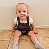 baby, child, smiling, sitting, floor, tile, socks, romper, clothing, indoor, person, head, face, happy, skin, young, cute, babywear, wall, texture
