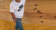 Armani joined the competition — help win amazing prizes! child, toddler, curly_hair, standing, portrait, smiling, indoors, wooden_structure, corn_kernels, farm, play_area, window, daylight, white_shirt, nike_shirt, jeans, wristband, brown_hair, curious, photography