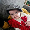 baby, blue_eyes, bow, cap, child, couch, cozy, cute, face, gray_fabric, hand, happy, indoor, infant, plush_toy, portrait, red_clothing, seated, smile, soft_lighting