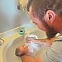 baby, newborn, man, beard, bathtub, bath, water, cloth, skin, face, arm, tattoo, indoor, parent, care, gentle, white, smile, bathroom, tender