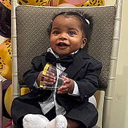 Alisia joined the competition — help win amazing prizes! baby, child, tuxedo, suit, bow_tie, chair, balloons, leopard_print, pink_balloon, smiling, happy, socks, indoor, celebration, party, cute, portrait, person, holding_object, festive
