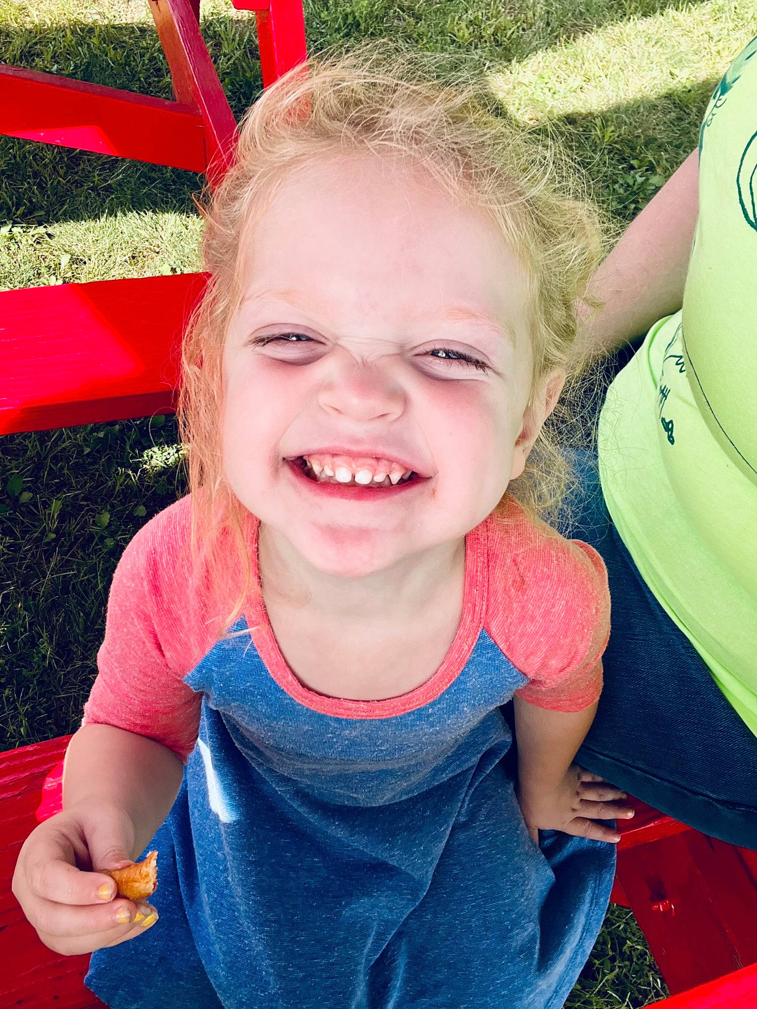 Madelyn is registered to the contest to win money with this photo: baby_toddler_clothing, child, chin, event, fun, gesture, grass, green, happy, joy, leisure, people_in_nature, person, pink, recreation, red, sitting, skin, smile, summer