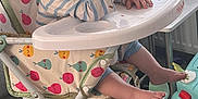 Rivver joined the competition — help win amazing prizes! baby, high_chair, food, indoor, child, toys, furniture, pouty_expression, striped_clothing, footrest, carpet, living_room, colorful_pattern, face, person, seat, cute, curious, hand, table