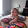 Sa'Riah is registered to the contest to win money with this photo: baby, infant, child, bed, pillow, floral_pattern, indoor, furniture, lamp, table, curious, skin, face, eyes, clothing, blanket, room, window, light, portrait