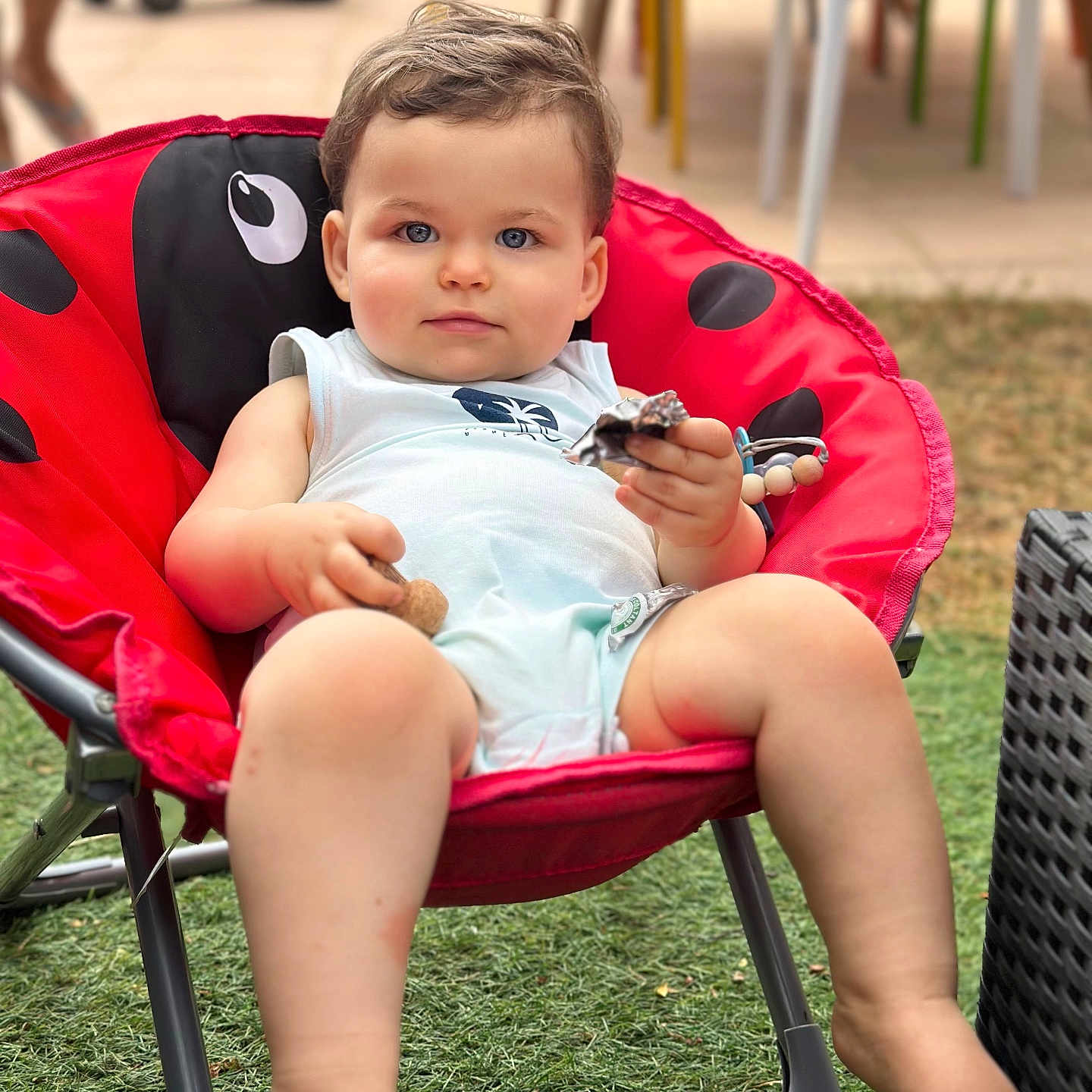 Andrea a rejoint le concours — aidez-le/la à gagner de superbes lots ! baby, barefoot, blue_eyes, casual, child, curly_hair, grass, ladybug_pattern, outdoor, plastic_chair, playtime, portrait, red_chair, relaxed, seat, snack, summer_clothing, sunlight, toddler, toy