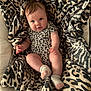 baby, infant, leopard_print, blanket, pattern, clothing, sock, cute, child, resting, soft_fabric, indoor, portrait, comfort, skin, face, hands, legs, cozy, warm