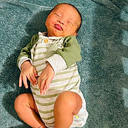 Daniel joined the competition — help win amazing prizes! baby, infant, child, onesie, striped_clothing, green_clothing, blanket, soft_texture, funny_face, tongue_out, lying_down, cute, adorable, skin, hand, foot, indoors, sleepy, relaxed, smiling