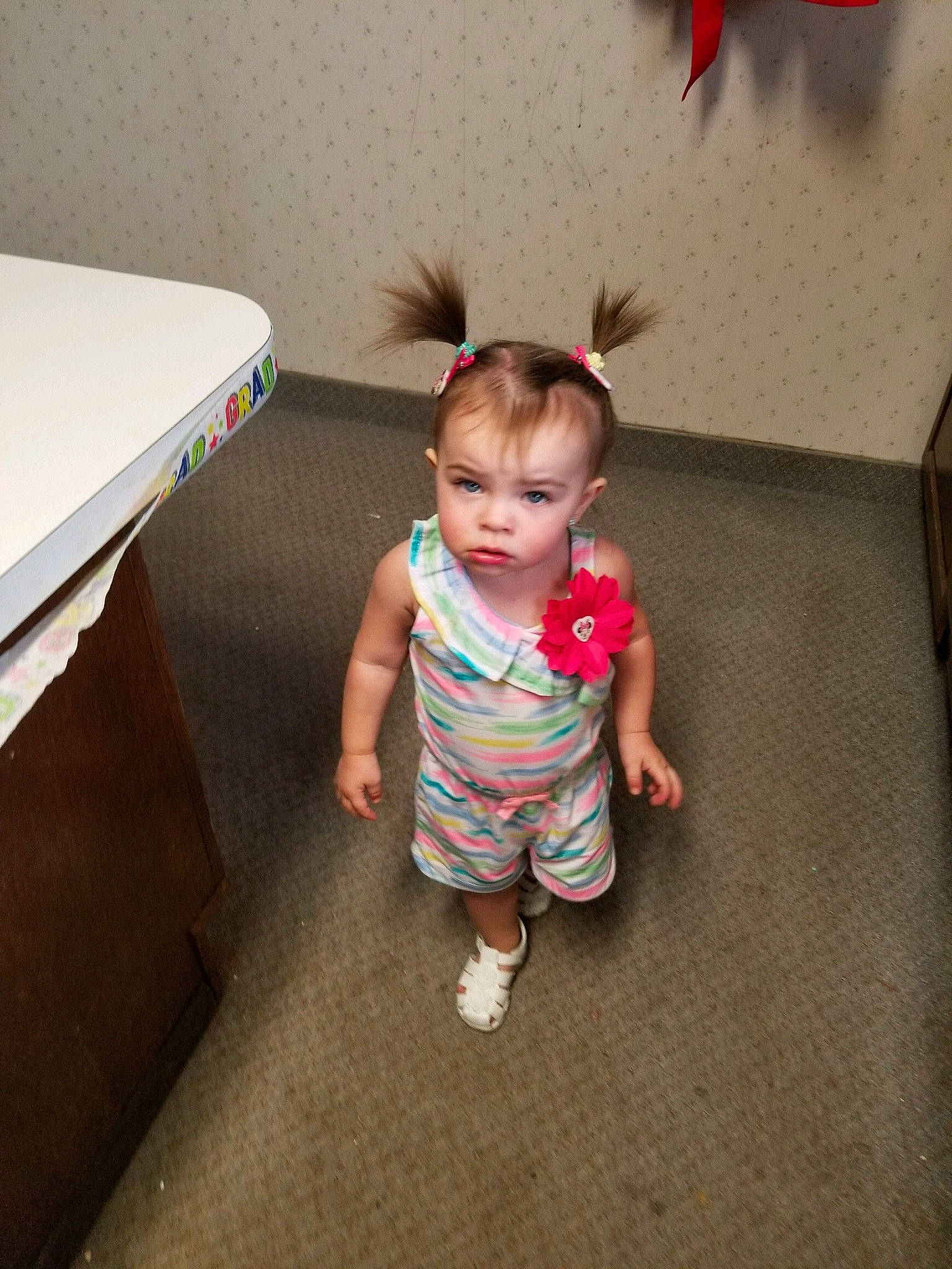 Cassie is registered to the contest to win money with this photo: baby, cheek, child, electronic_device, floor, flooring, fun, head, leg, person, play, sitting, skin, smile, standing, table, technology, toddler