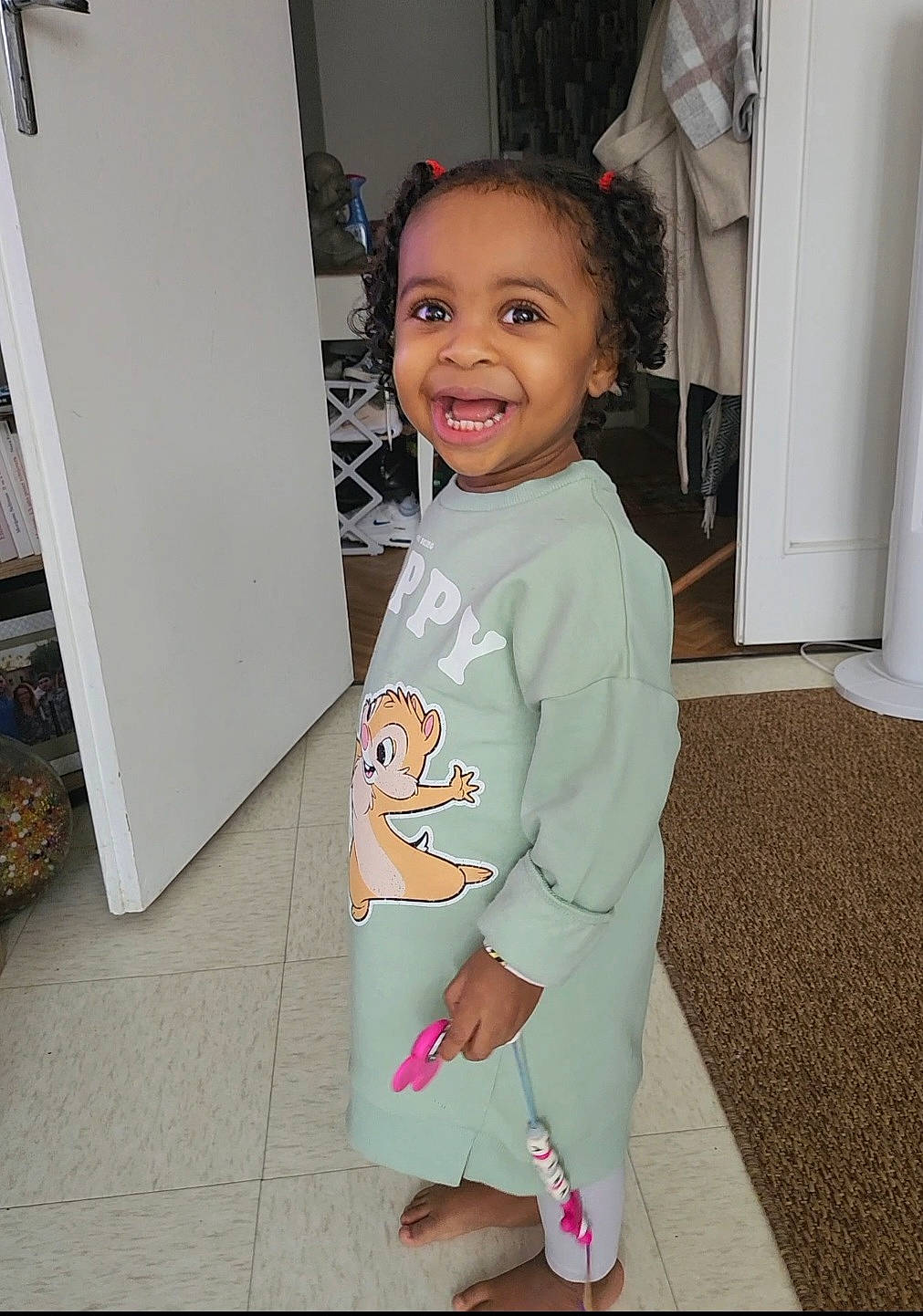 Maïra participe au concours pour gagner de l'argent avec cette photo : baby, baby_toddler_clothing, child, face, fashion_design, floor, flooring, fun, hair, happy, hardwood, joint, joy, person, room, shoulder, skin, sleeve, smile, t_shirt