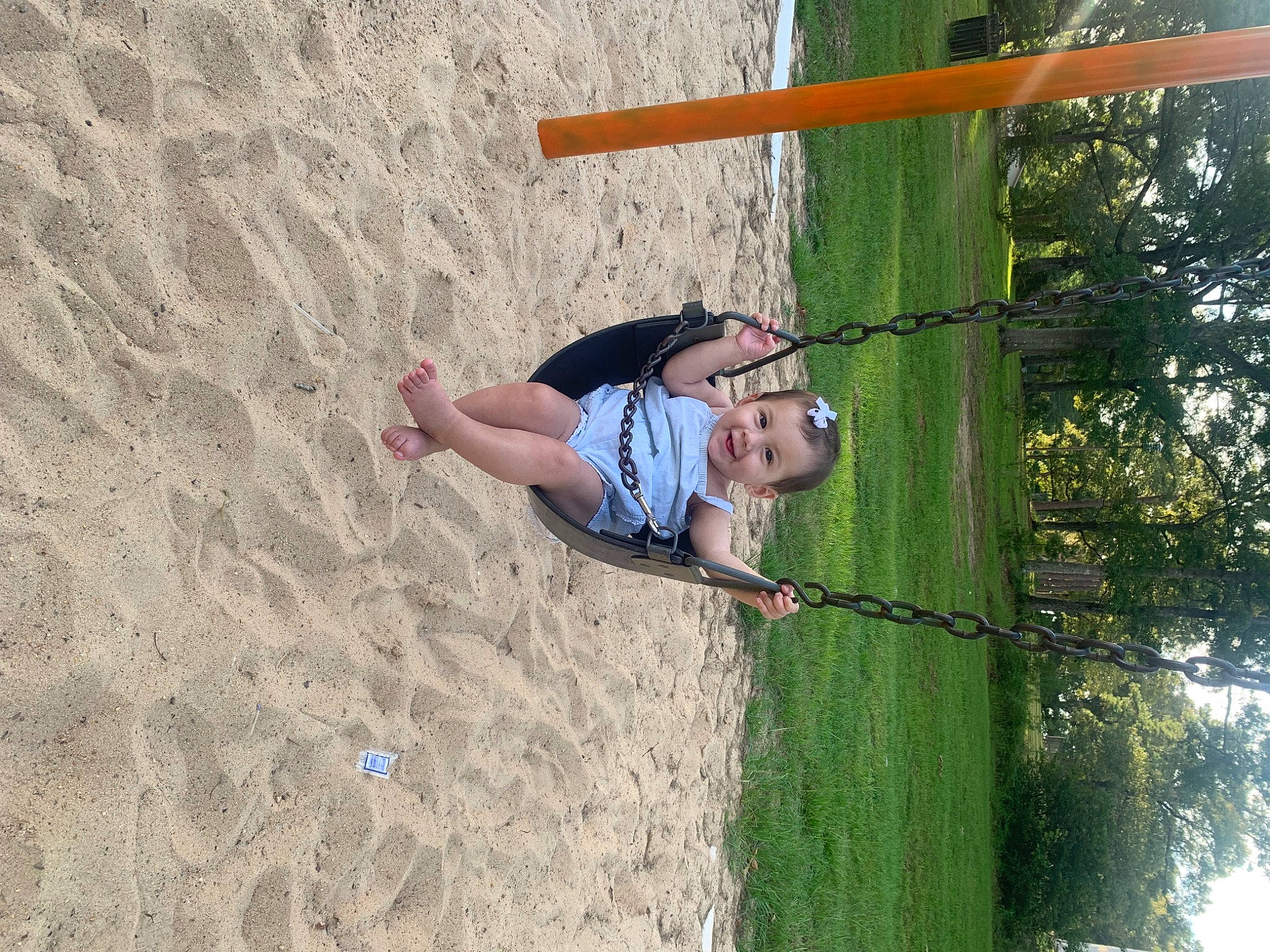 Everleigh Rose is registered to the contest to win money with this photo: adventure, climbing_harness, elbow, fun, grass, happy, joy, landscape, leisure, outdoor_play_equipment, people_in_nature, person, playground, recreation, shorts, sky, smile, soil, toddler, tree