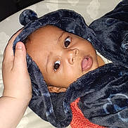 Leo is registered to the contest to win money with this photo: baby, child, infant, hooded_blanket, blue_blanket, hand, face, eyes, cozy, soft, cute, portrait, lying_down, blanket, bed, comfort, warm, clothing, expression, indoor