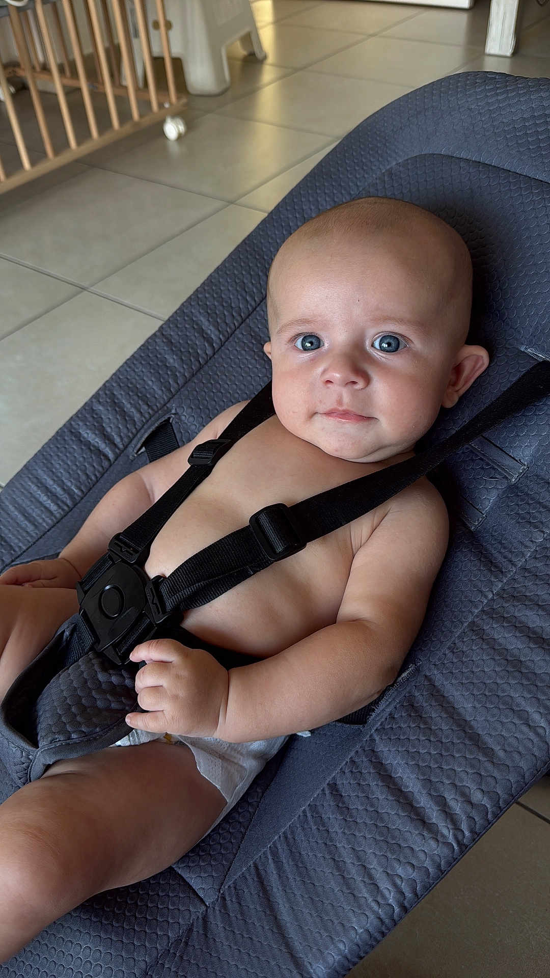 Ezio a rejoint le concours — aidez-le/la à gagner de superbes lots ! baby, infant, child, blue_eyes, seat, baby_seat, straps, diaper, indoor, floor_tiles, wooden_furniture, curious, looking_at_camera, relaxed, skin, hand, arm, head, face, expression
