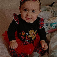 Naylani joined the competition — help win amazing prizes! baby, child, girl, plaid, bow, holiday, christmas, bed, blanket, clothing, cute, sitting, portrait, indoors, smile, festive, toddler, red, black, warm