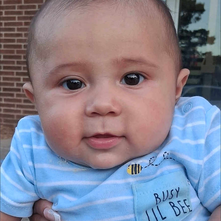 Luciano joined the competition — help win amazing prizes! baby, child, infant, blue_clothing, striped_shirt, outdoor, brick_wall, person, cute, face, hand, holding, expression, curious, young, head, eyes, skin, casual, summer