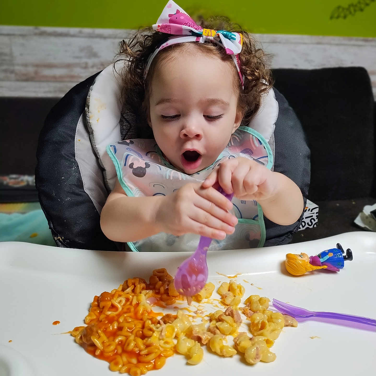 Lyla is registered to the contest to win money with this photo: baby, cream, cutlery, diningtable, dish, eating, face, food, fork, furniture, head, lunch, macandcheese, meal, person, photography, portrait, snack, spoon, table