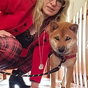 Keyo a rejoint le concours — aidez-le/la à gagner de superbes lots ! woman, dog, shiba_inu, indoor, leash, glasses, red_jacket, plaid_pants, wooden_fence, floor, footwear, black_boots, necklace, pet, crouching, light, fence, animal, person, casual