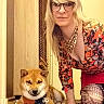 Keyo a rejoint le concours — aidez-le/la à gagner de superbes lots ! woman, dog, shiba_inu, glasses, indoor, carpet, bandana, blonde_hair, patterned_clothing, kneeling, pet, floor, smiling, portrait, animal, person, furniture, home, decor, casual