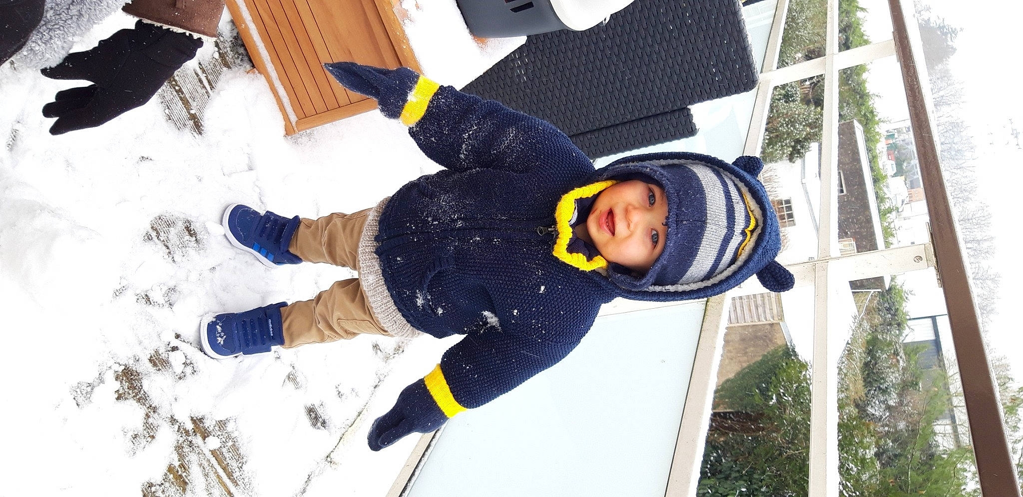 Sohan participe au concours pour gagner de l'argent avec cette photo : child, freezing, fun, headwear, jacket, leisure, person, personal_protective_equipment, plant, recreation, smile, snow, toddler, tree, window, winter