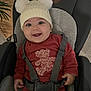 Livia a rejoint le concours — aidez-le/la à gagner de superbes lots ! baby, child, smile, hat, pom_poms, red_clothing, car_seat, harness, indoor, face, happy, cute, cozy, infant, person, seat, knit_hat, toddler, plush_design, sitting