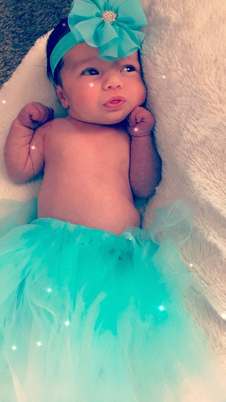 Aliegha is registered to the contest to win money with this photo: aqua, arm, azure, baby, baby_toddler_clothing, blue, cap, face, facial_expression, finger, flash_photography, hairstyle, hand, happy, headwear, iris, light, person, photograph, pink