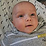 baby, infant, face, blue_eyes, curious, lying_down, striped_shirt, mickey_and_friends, mustache_pattern, blanket, close_up, child, cute, soft_skin, indoors, young_child, portrait, head, expression, person