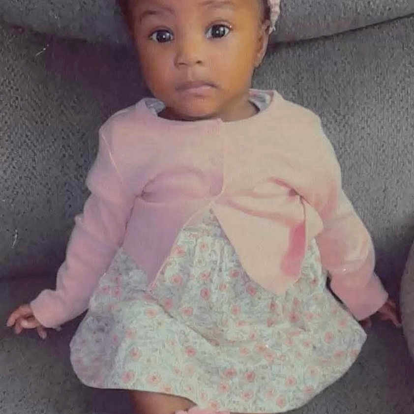 Lahretta is registered to the contest to win money with this photo: baby, child, couch, cozy, curious_expression, cute, floral_dress, girl, gray_couch, headband, indoor, infant, person, pink_cardigan, pink_headband, pink_socks, portrait, sitting, toddler, wide_eyes