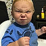Jaxon is registered to the contest to win money with this photo: toddler, child, baby, blue_shirt, high_chair, fist, angry_expression, blond_hair, indoor, person, face, portrait, furniture, home, cute, determined, expression, sitting, closeup, young