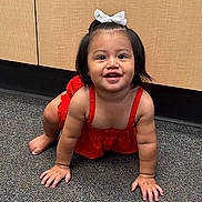 Mia joined the competition — help win amazing prizes! toddler, child, crawling, red_dress, white_bow, smiling, carpet, floor, indoor, cabinet, furniture, young_child, cute, happy, person, portrait, baby, skin, hair, hands