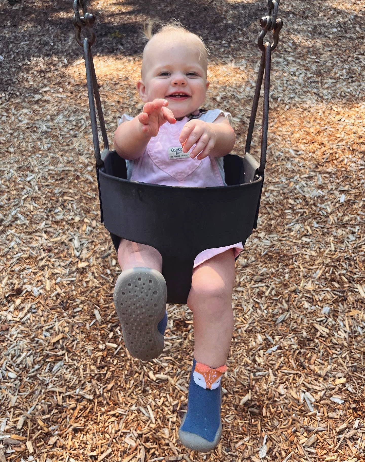 Lilah joined the competition — help win amazing prizes! arm, baby, eye, face, finger, fun, grass, hand, happy, head, human_body, joy, knee, leisure, people_in_nature, person, playground, sleeve, smile, swing