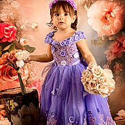 Danna Paola is registered to the contest to win money with this photo: bouquet, celebration, child, cute, dress, elegant, floral_background, flower_arrangement, flower_crown, girl, headband, indoor, person, photography, portrait, purple_dress, roses, smiling, standing, toddler