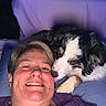 Cookie joined the competition — help win amazing prizes! affection, canine, closeup, comfort, cuddle, dog, face, friendship, fur, happy, head, human, indoor, licking, person, pet, pillow, purple_shirt, resting, smile
