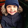 Owen participe au concours pour gagner de l'argent avec cette photo : child, smiling, winter_clothing, knit_hat, fur_hood, jacket, bench, indoor, window, happy, face, person, cute, warm_clothing, portrait, young_child, cozy, casual, sitting, bright_eyes