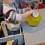 Owen a rejoint le concours — aidez-le/la à gagner de superbes lots ! toddler, child, sweater, striped_clothing, mixing_bowl, kitchen, pouring, whisk, table, chair, indoor, home, toy, jeans, footwear, cooking, person, furniture, activity, concentration