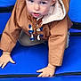 activity, blue_inflatable, brown_jacket, casual_wear, child, crawling, curious, expression, face, fun, hands, hooded_clothing, inflatable_surface, light_hair, outdoor, person, play, playground, toddler, young_child