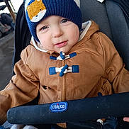 Maël a rejoint le concours — aidez-le/la à gagner de superbes lots ! toddler, child, baby, hat, knit_hat, bear_patch, jacket, brown_jacket, stroller, baby_stroller, blanket, blue, white, face, portrait, outdoor, winter_clothing, cute, person, seated