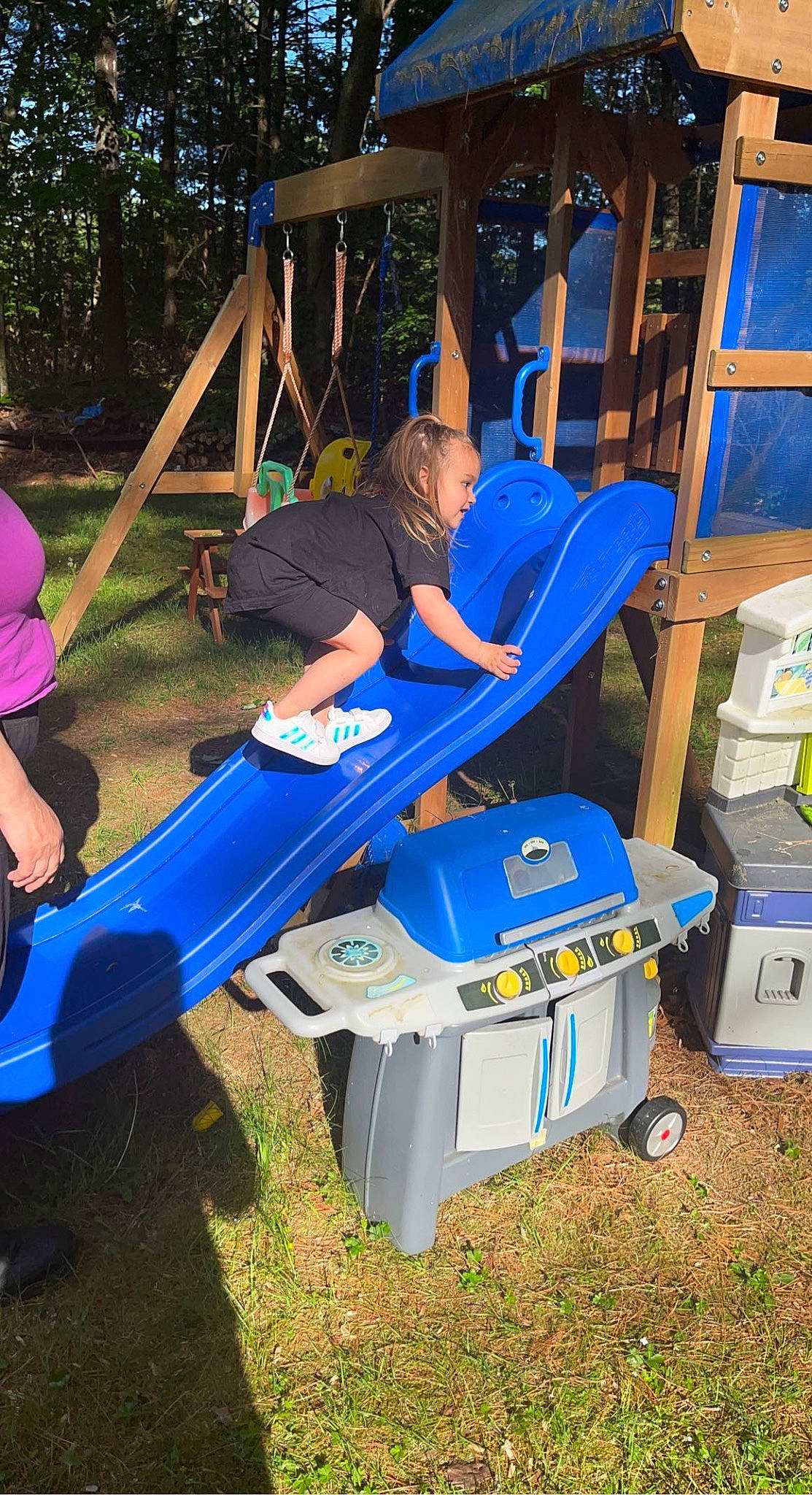 Lilliana is registered to the contest to win money with this photo: automotive_exterior, bumper, chute, city, electric_blue, fun, grass, hat, leisure, machine, outdoor_play_equipment, person, plant, plastic, play, playground, recreation, shade, shorts, t_shirt