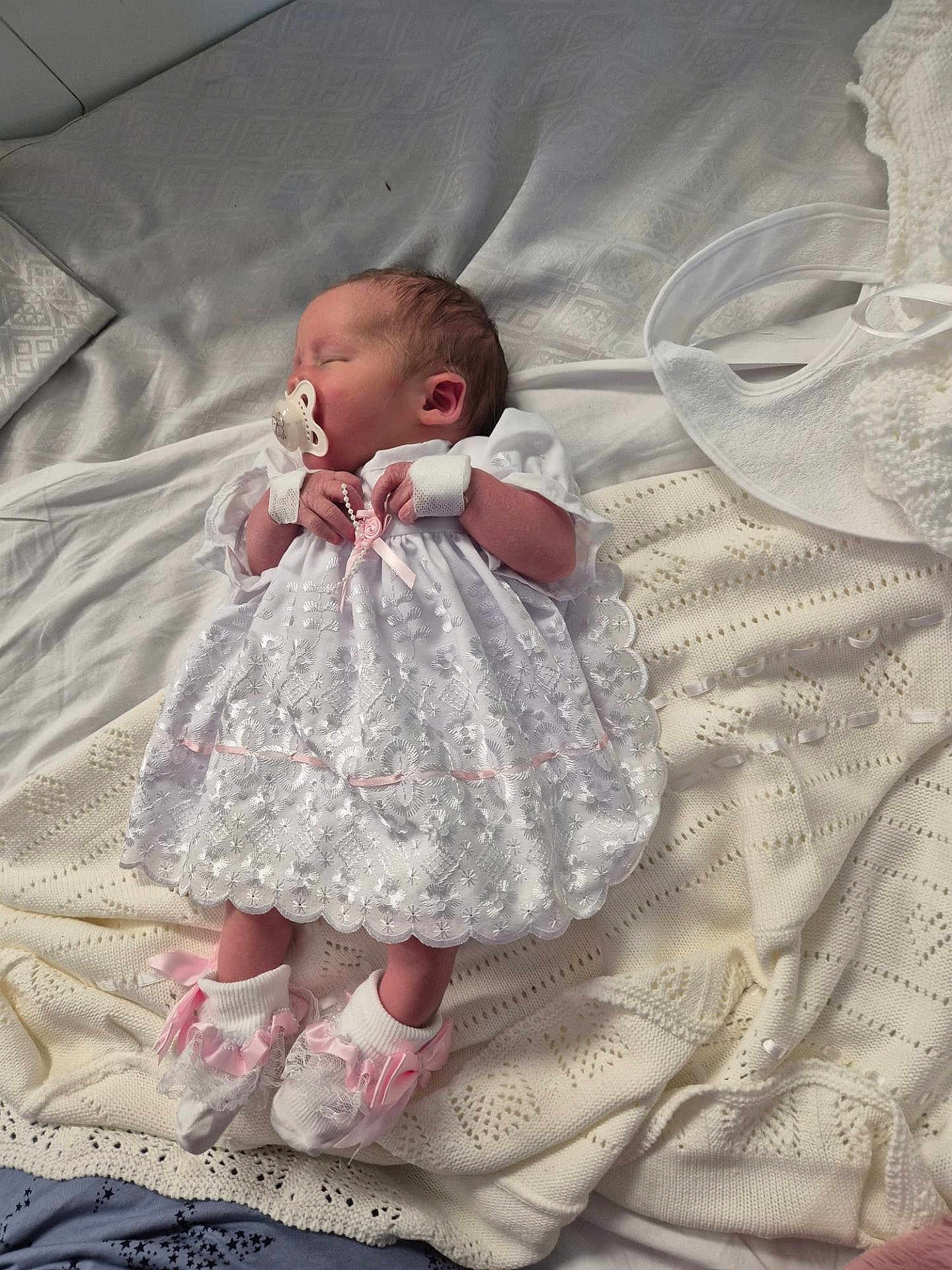 Georgia is registered to the contest to win money with this photo: newborn, baby, sleeping, pacifier, white_dress, lace, pink_booties, blanket, knitwear, infant, cute, peaceful, indoors, soft_lighting, portrait, closeup, resting, small_hands, cozy, delicate