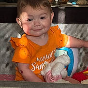 Nova joined the competition — help win amazing prizes! toddler, child, smile, orange_shirt, stuffed_animal, playpen, toy, indoor, happy, cute, face, person, young_child, plush_toy, sunlight, shadow, home, furniture, clothing, infant