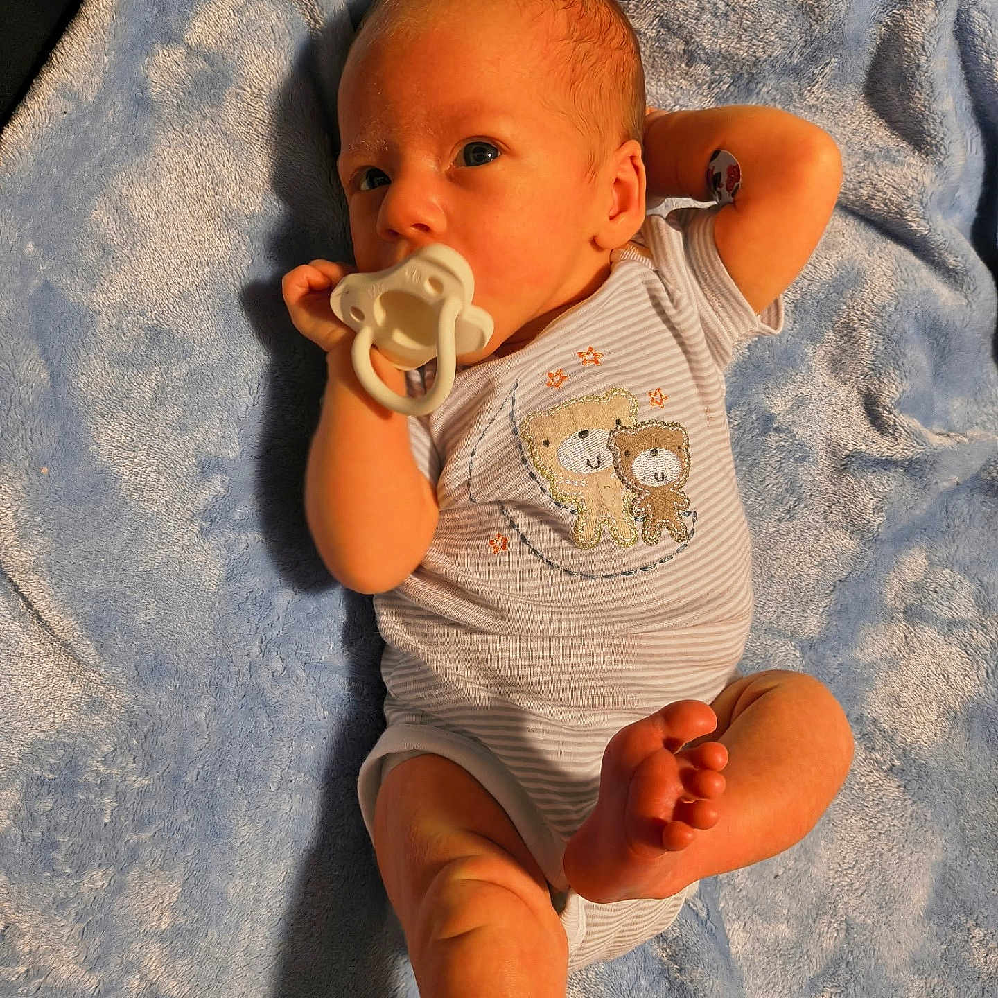 Braxton is registered to the contest to win money with this photo: baby, barefoot, blue_blanket, child, cute, embroidered_clothing, indoors, infant, lying_down, newborn, onesie, pacifier, portrait, relaxed_pose, skin, sleepwear, small_foot, small_hand, soft_texture, young